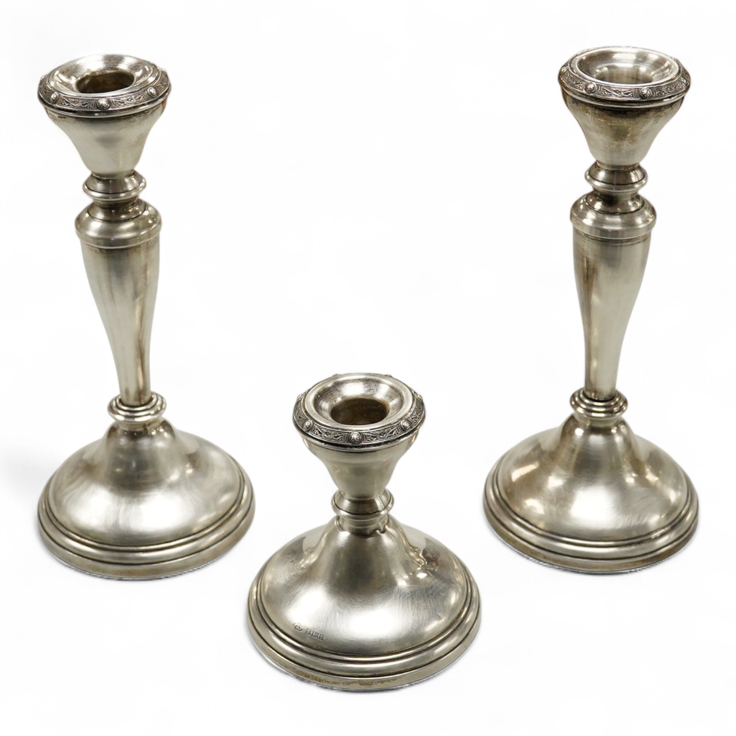 A suite of three Elizabeth II silver mounted candlesticks, comprising a pair, 20.3cm and a single dwarf candlestick, Adie Brothers, Birmingham, 1956.